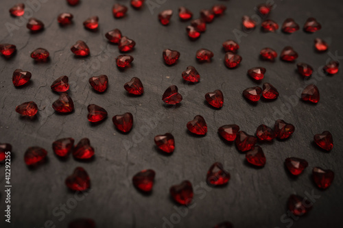  Close-up on a red glass hearts on a dark background. Valentine's concept. Symbol of love and Valentine's day.