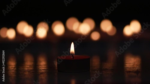 candle in night, a luminous candle in the dark on bokeh light-background.