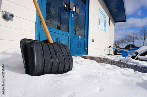 Foto Against slippery conditions, the use of a snow shovel for freeing the street from snow and ice