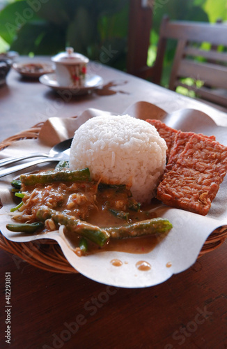 Close up of pecel rice on a wooden table. Pecel rice is a traditional food from Java, Indonesia  photo