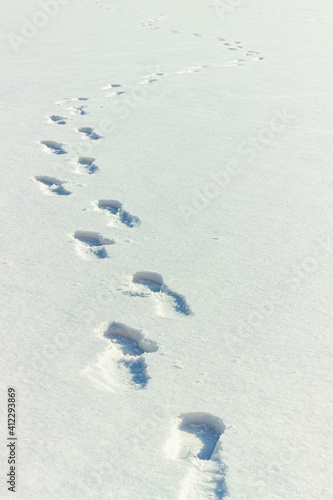 Human footprints on snow. Footsteps on winter frozen lake surface