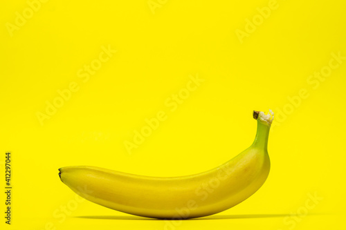 Banana on a yellow background. Fresh yellow banana. One banana in the center of the frame. Exotic fruit