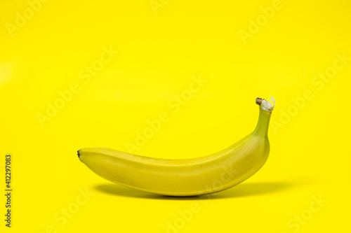 Banana on a yellow background. Fresh yellow banana. One banana in the center of the frame. Exotic fruit