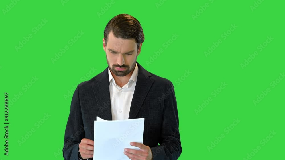 Young business man looking through the documents on a Green Screen, Chroma Key. Young business man looking through the documents on a Green Screen, Chroma Key.