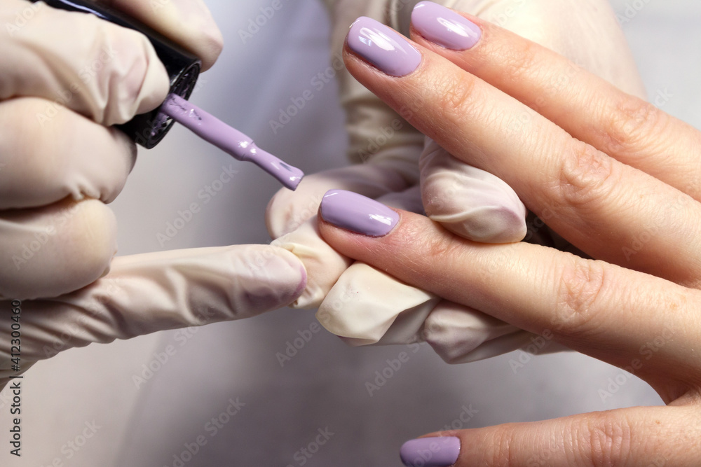 The process of manicure fitting natural nails filing nails coating with colored gel polish and glossy top. The process of manicure fitting natural nails filing nails coating with colored gel polish and glossy top.