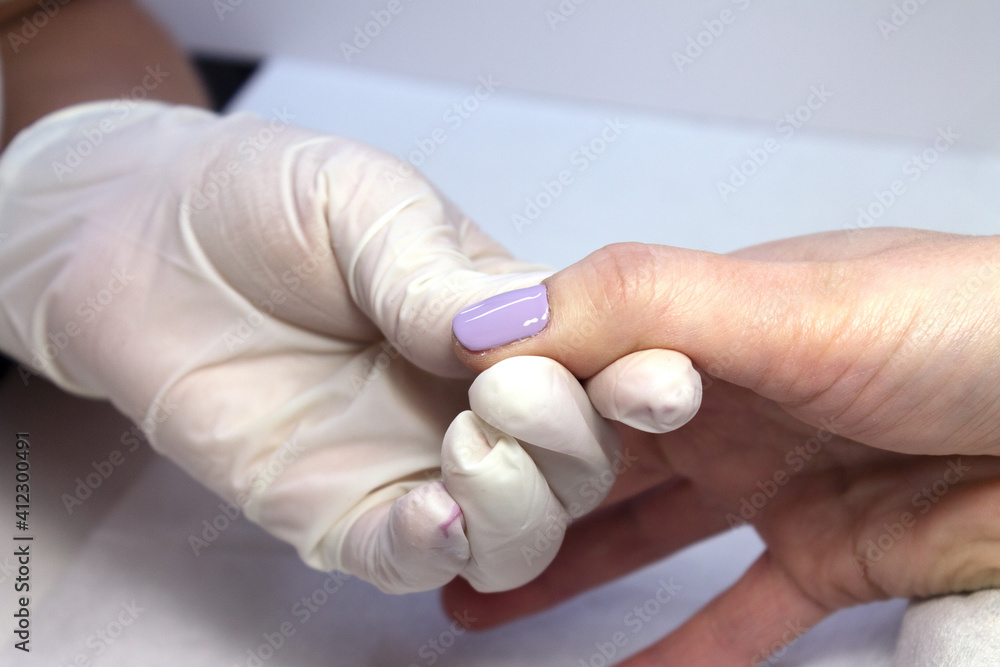 The process of manicure fitting natural nails filing nails coating with colored gel polish and glossy top. The process of manicure fitting natural nails filing nails coating with colored gel polish and glossy top.