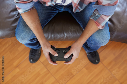 closeup man sitting on the sofa at home, playing a video game