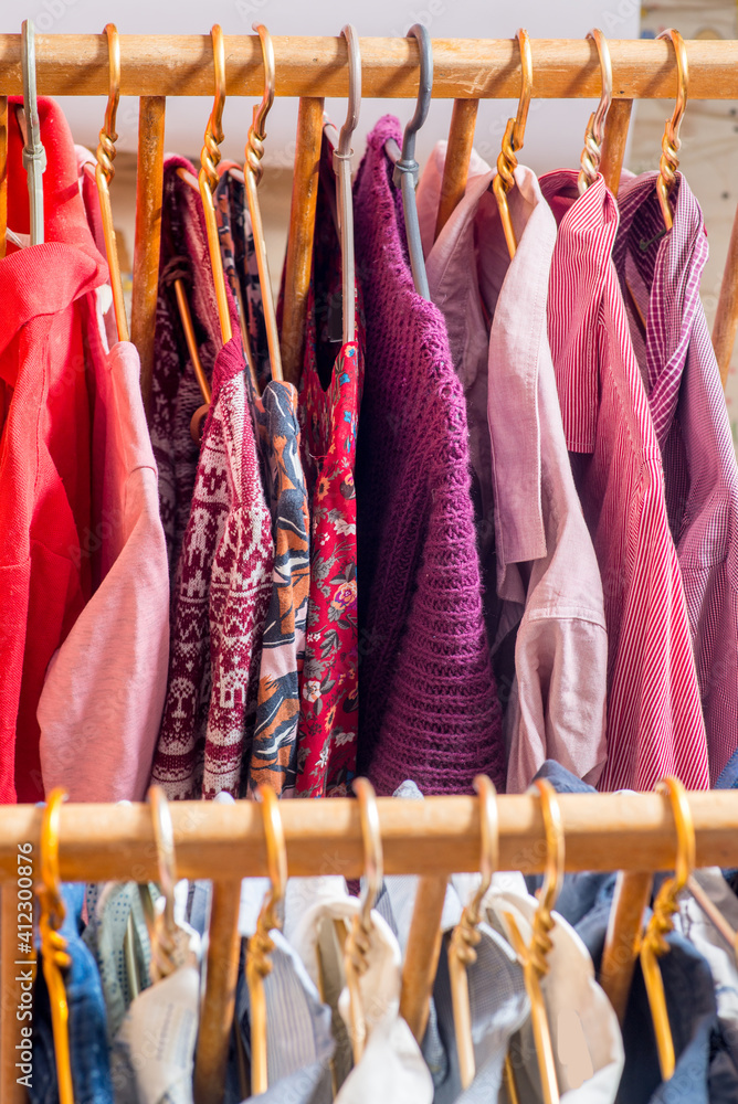 Fototapeta premium Clothes are hanging on hangers. Lots of clothes for sorting things in the wardrobe.