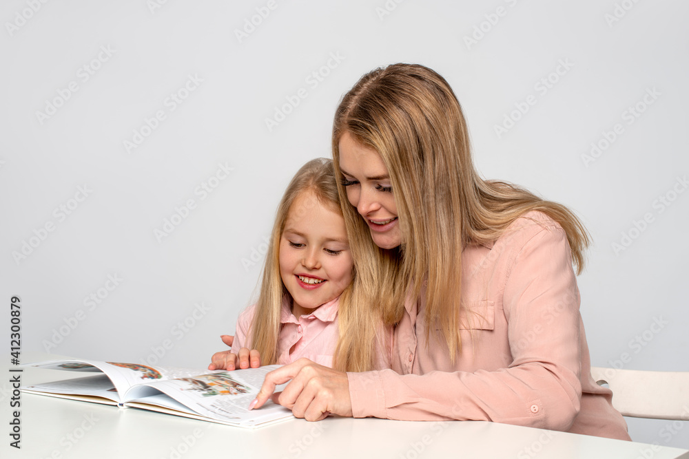 Mom helps little daughter to do homework Mom helps little daughter to do homework