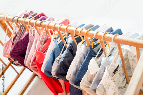 Clothes are hanging on hangers. Lots of clothes for sorting things in the wardrobe.