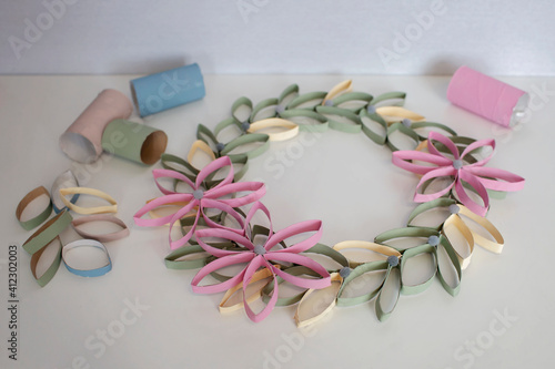 Wreath from toilet roll tube for Easter celebration, zero waste craft for kids, school and kindergarten, creative seasonal idea for spring holidays and leisure, plain neutral pastel background