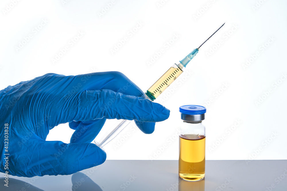 Fototapeta premium Male doctor hand in blue glove holds syringe and vial bottle with drug multiple injections dose.