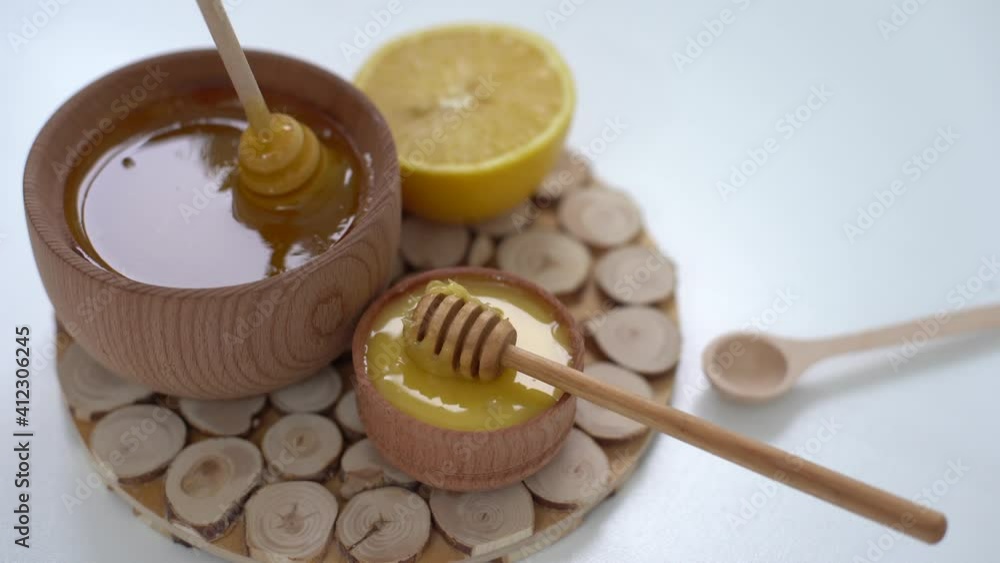 cropped view of woman mixing honey with lemon on white background. cropped view of woman mixing honey with lemon on white background.