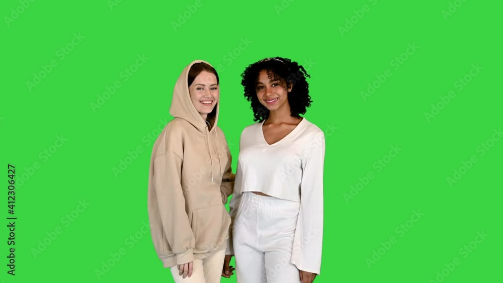 Two mixed race girls looking into the camera on a Green Screen, Chroma Key. Two mixed race girls looking into the camera on a Green Screen, Chroma Key.