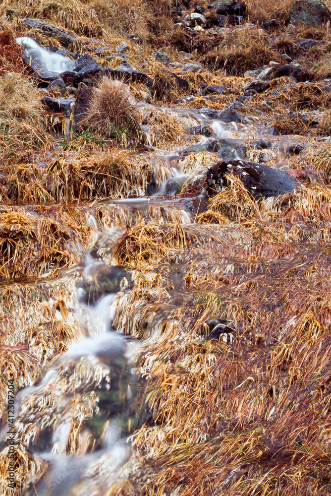 Mountain stream and orange grass in Autumn. Cumbria, UK. Mountain stream and orange grass in Autumn. Cumbria, UK.