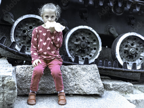 little sad girl eating near the tank