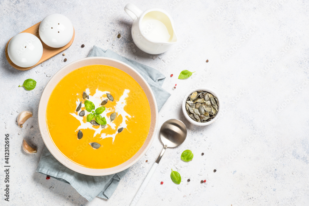 Pumpkin soup with cream. Top view image at white table. Pumpkin soup with cream. Top view image at white table.