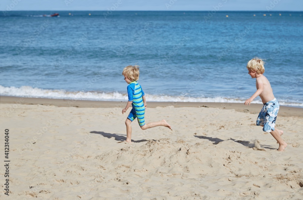 Children having fun playing on the beach together Children having fun playing on the beach together