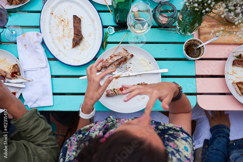 Close-up of unrecognizable person eating delicious food at dinner .From above