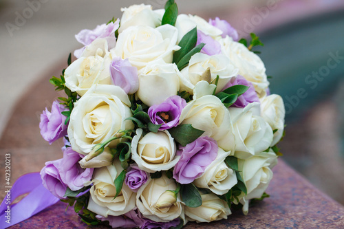 Beautiful wedding bouquet of natural flowers on a blurred background lies on granite