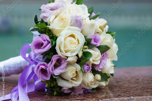 Beautiful wedding bouquet of natural flowers on a blurred background lies on granite