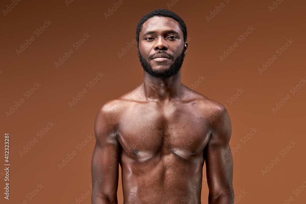 afro sportsman posing after active intense training, he is looking at camera, sweaty and exhausted