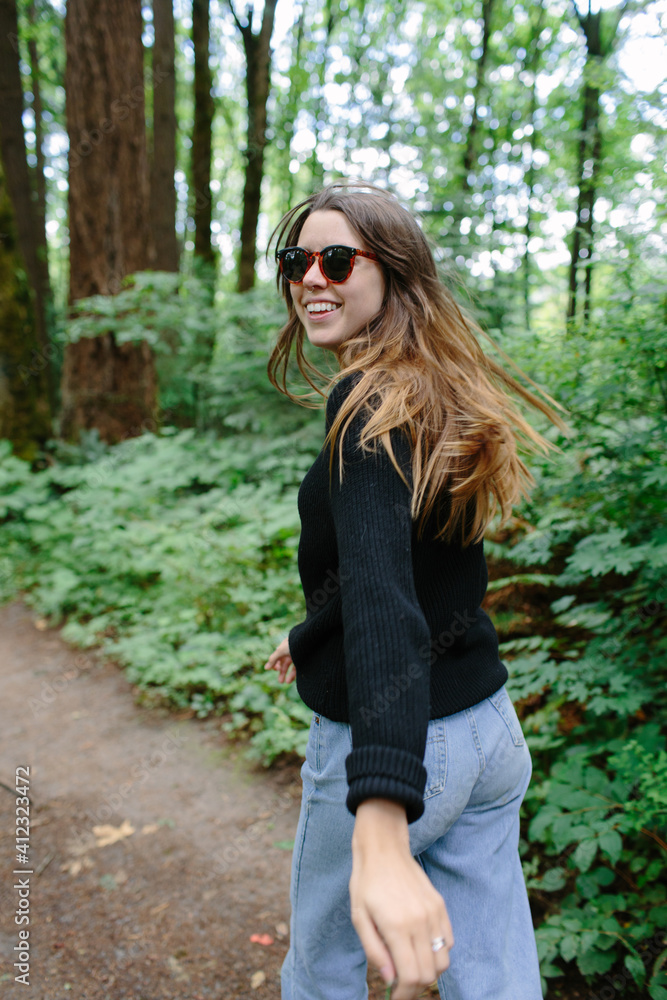 woman running and laughing through the woods woman running and laughing through the woods