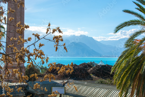 View of the blue sea and the mountains of Antalya from the old town under the blue sky with white clouds on a sunny day in winter