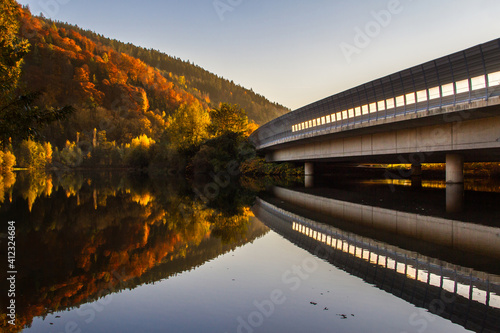 Foto Idyllic nature in autumn with bridge and water reflection