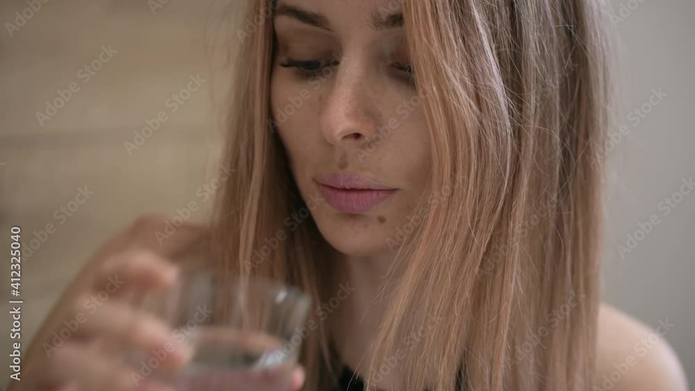 Attractive woman taking supplements pills and drink a glass of water Attractive woman taking supplements pills and drink a glass of water