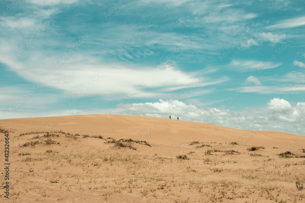 two people walking in the dunes two people walking in the dunes