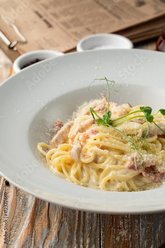 Classic carbonara spaghetti with grated parmesan close up, juicy yummy shot