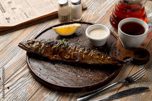 Rustic-style roasted fish with head, wooden plate, soft light, food magazine photo photo