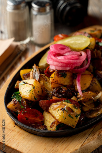 Fotografie Close up of potato and meat stew with herbs and onion in a cast-iron, comfort fo