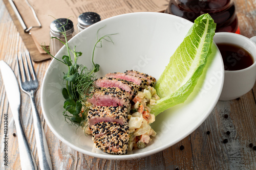 Raw roasted tuna fillet with sesame coat and sprouts, close appetizing photo photo