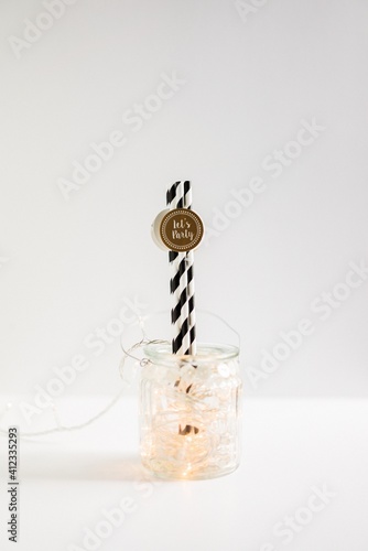 Glass jar filled with lights and straws with text 