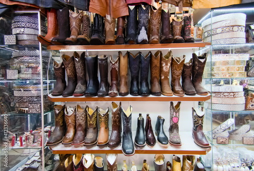 Stand displaying cowboys leather boots , long and short in different colors and styles