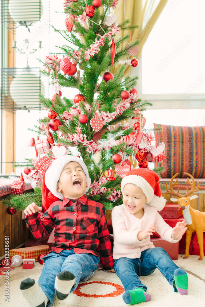 Girl and boy laughing under Christmas tree Girl and boy laughing under Christmas tree
