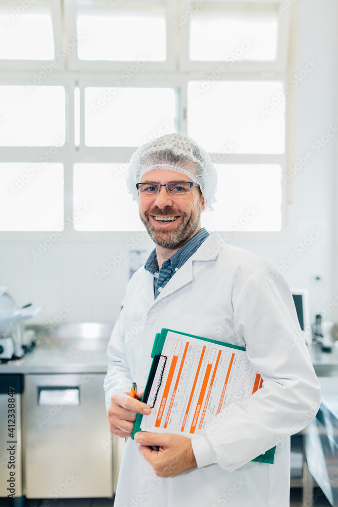 Portrait of a kitchen supervisor holding documents Portrait of a kitchen supervisor holding documents
