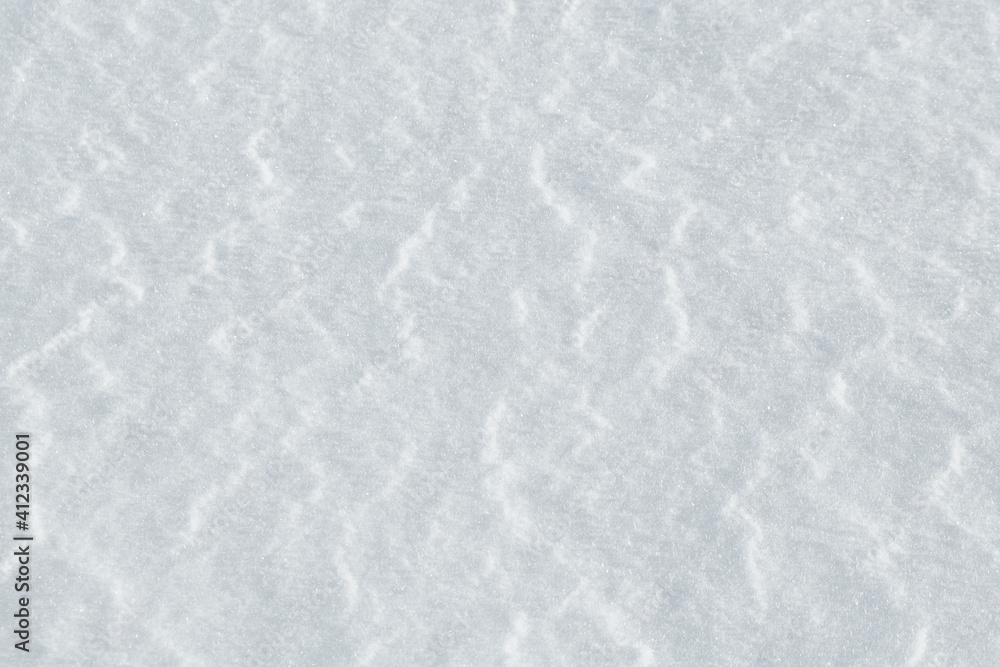 Background of snow with a light texture of wind waves. 