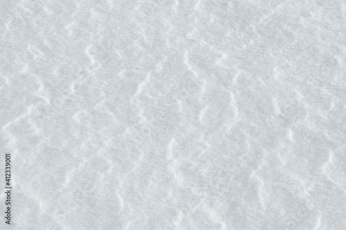 Background of snow with a light texture of wind waves. 