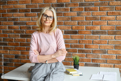 Foto Portrait of an elegant stylish mature middle-aged blonde businesswoman, ceo in g