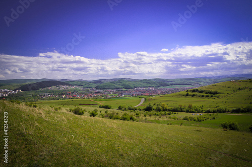Landscape of meadow and the view of the city from outside. Summer time.