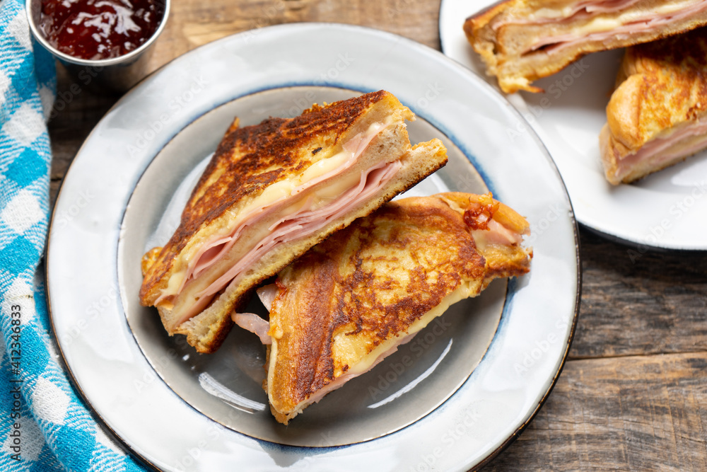 Ham and melted cheese sandwich called Monte Cristo on wooden background Ham and melted cheese sandwich called Monte Cristo on wooden background