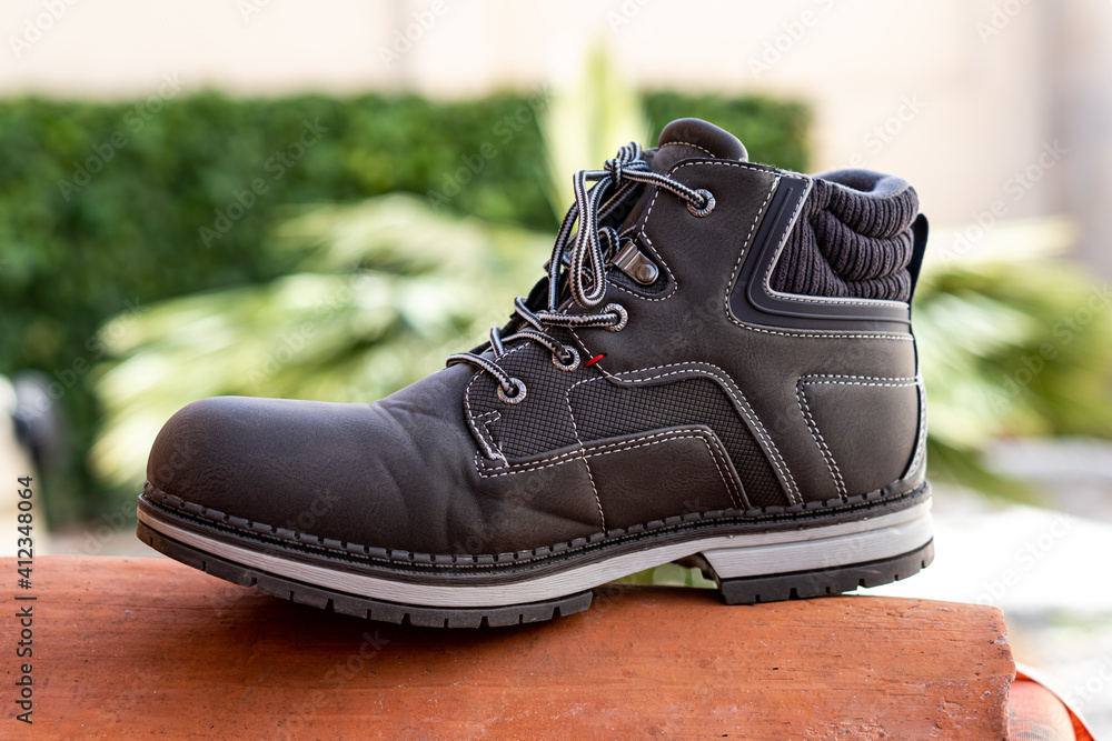 Selective focus of a gray boot for walking in the city on a decorative tile Selective focus of a gray boot for walking in the city on a decorative tile