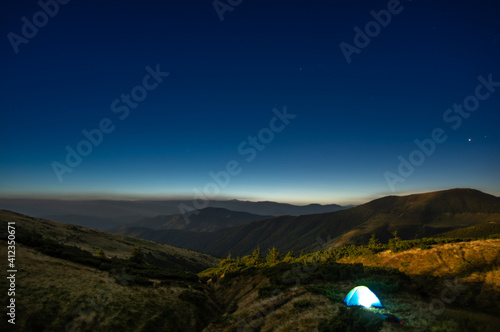 Tent against the background of the starry sky in the carpathian mountains