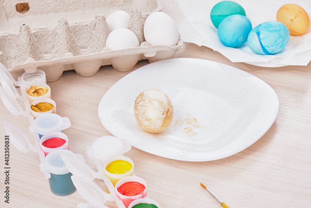 process of painting eggs for easter, eggs box, easter eggs, plate, brushes and paints on the table process of painting eggs for easter, eggs box, easter eggs, plate, brushes and paints on the table