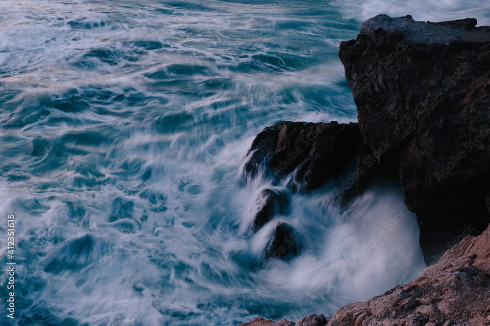 Waves and water on the rocky California coastline at dusk