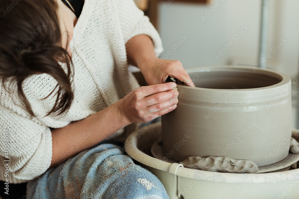 Young female potter working in her studio Young female potter working in her studio