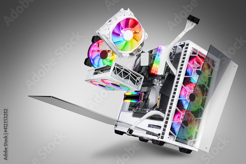 exploded view of white gaming pc computer with glass windows and rainbow rgb LED lights. Flying hardware components abstract concept technology gray background photo